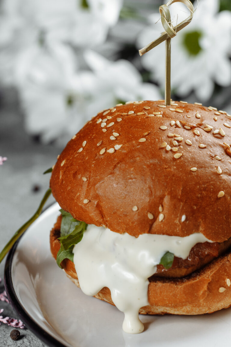 burger with fries and sauce on a white plate